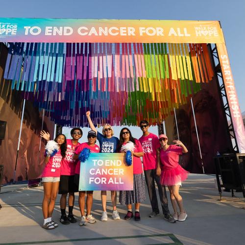 group of people holding to end cancer for all sign