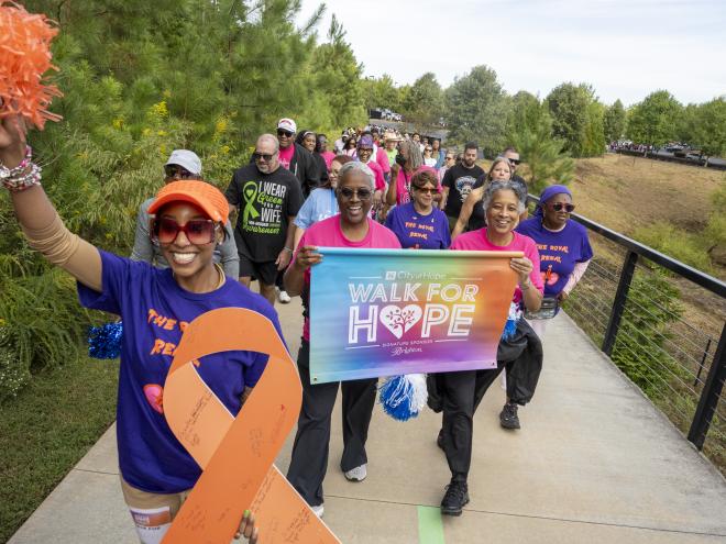 group of people walking holding sign