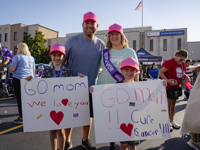 family holding go mom we love you signs
