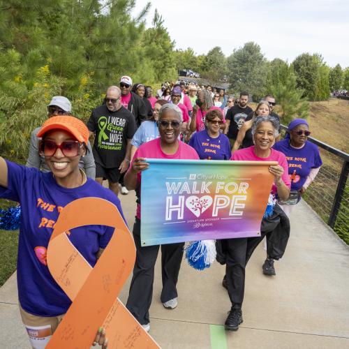 group of people walking holding sign