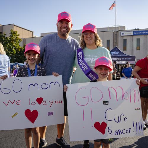 family holding go mom we love you signs